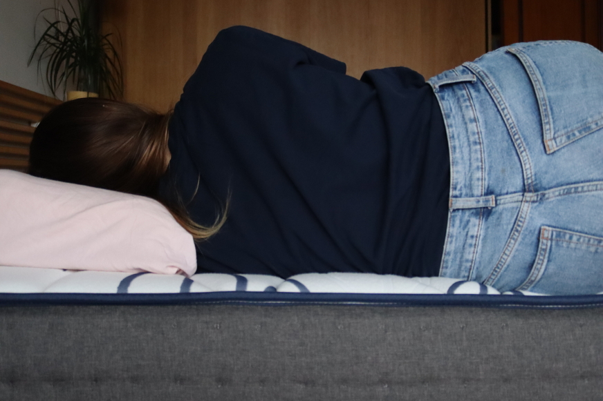 Pessoa deitada de lado no colchão